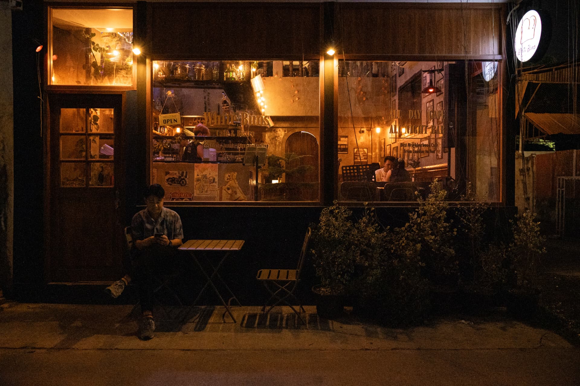 Exterior storefront of White Buns Cafe & Bistro in Khon Kaen at night